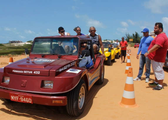 O presidente do SindBuggy, Luiz Thiago, de camisa vermelha, explica aos turistas a cobrança da taxa.