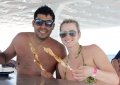 O casal Isabella e Antônio, do município de Passos Maia, no Oeste de SC, comendo espetinho de lagosta na plataforma de apoio do mergulho da Maracajaú Diver.