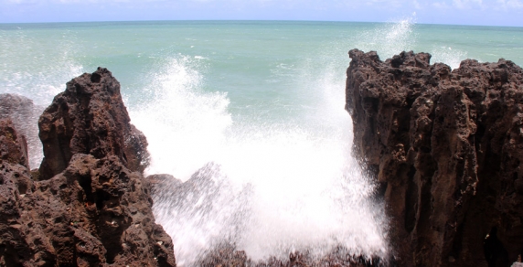 Com a subida da maré, as ondas batem nas rochas.