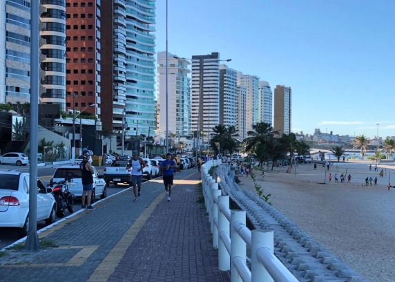 No calçadão da praia de Miami Beach pedestre ainda caminham na tarde de sexta-feira, mesmo com a prefeitura recomendando à população permanecer em casa. 